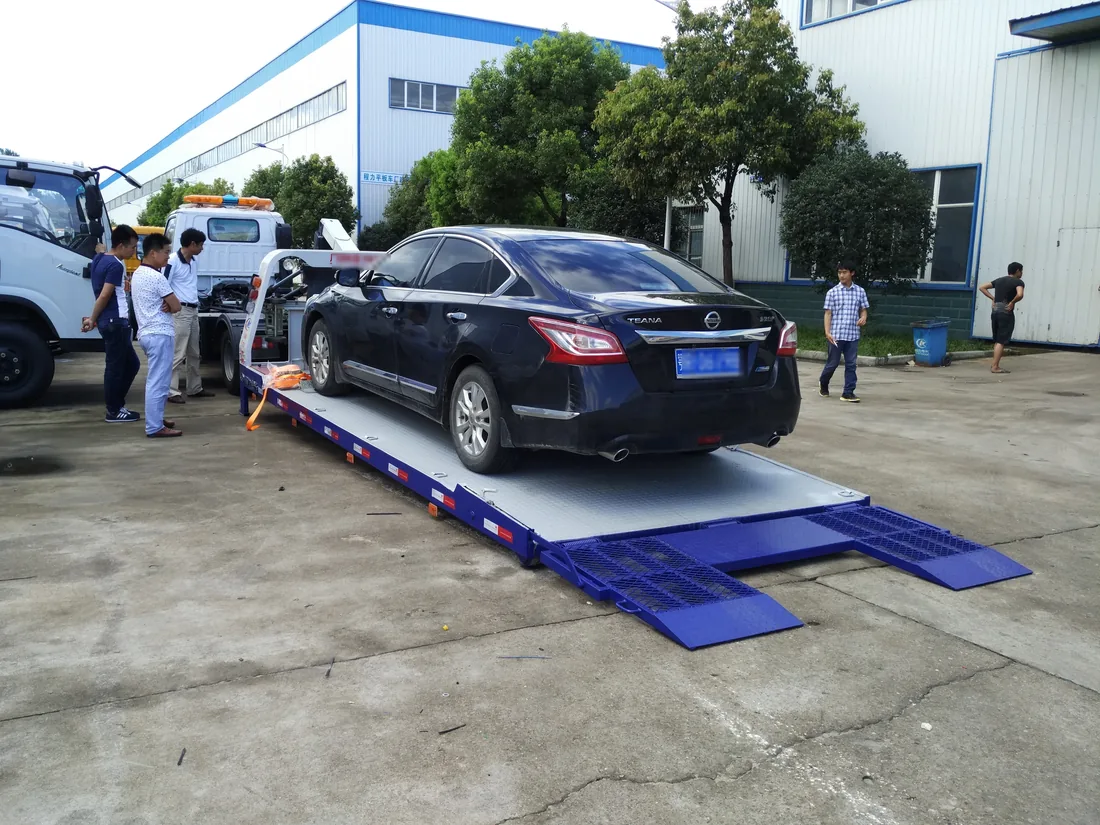 Drop-down flatbed bed loading a car with rear ramps